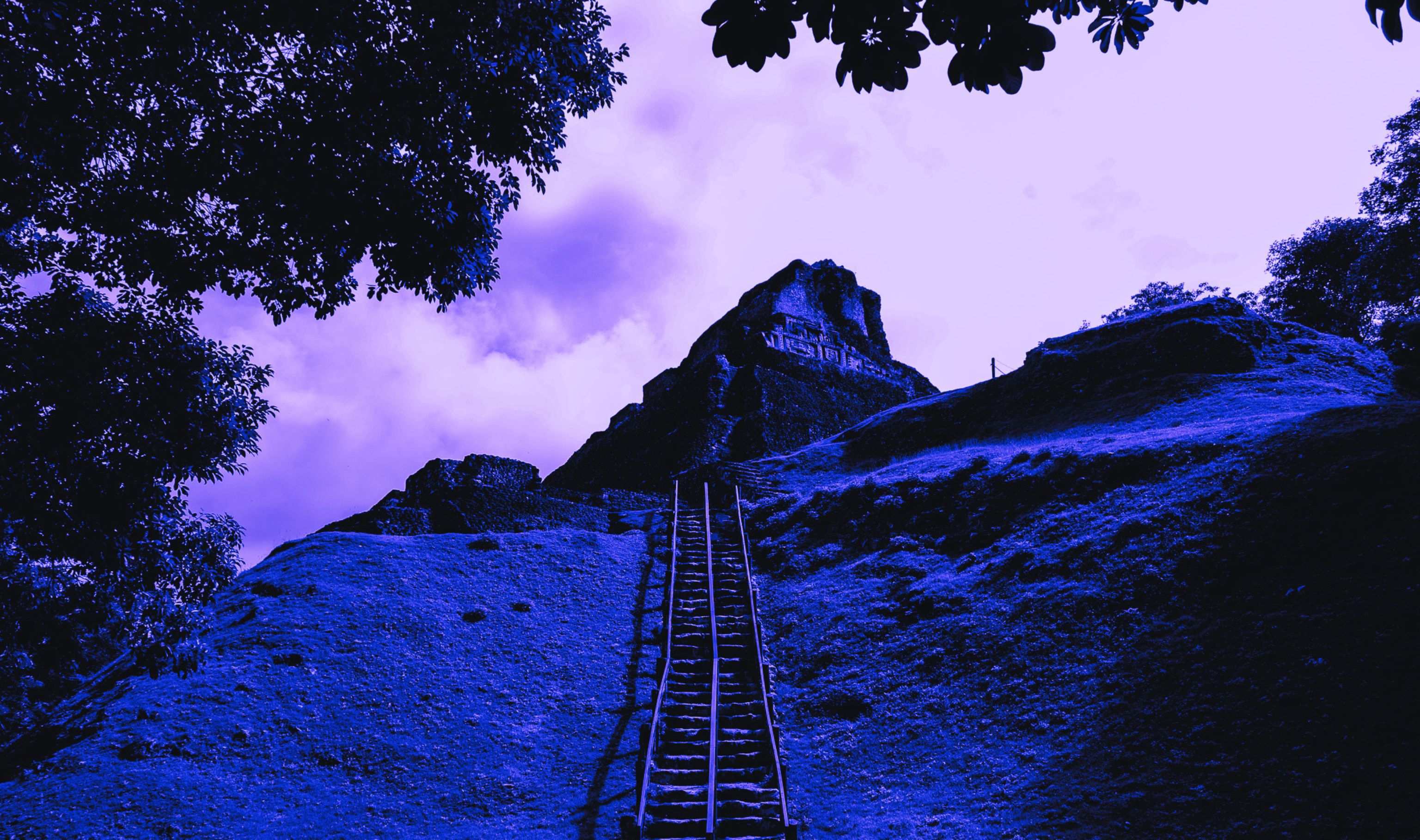Stone staircase climbing a Mayan pyramid at dusk